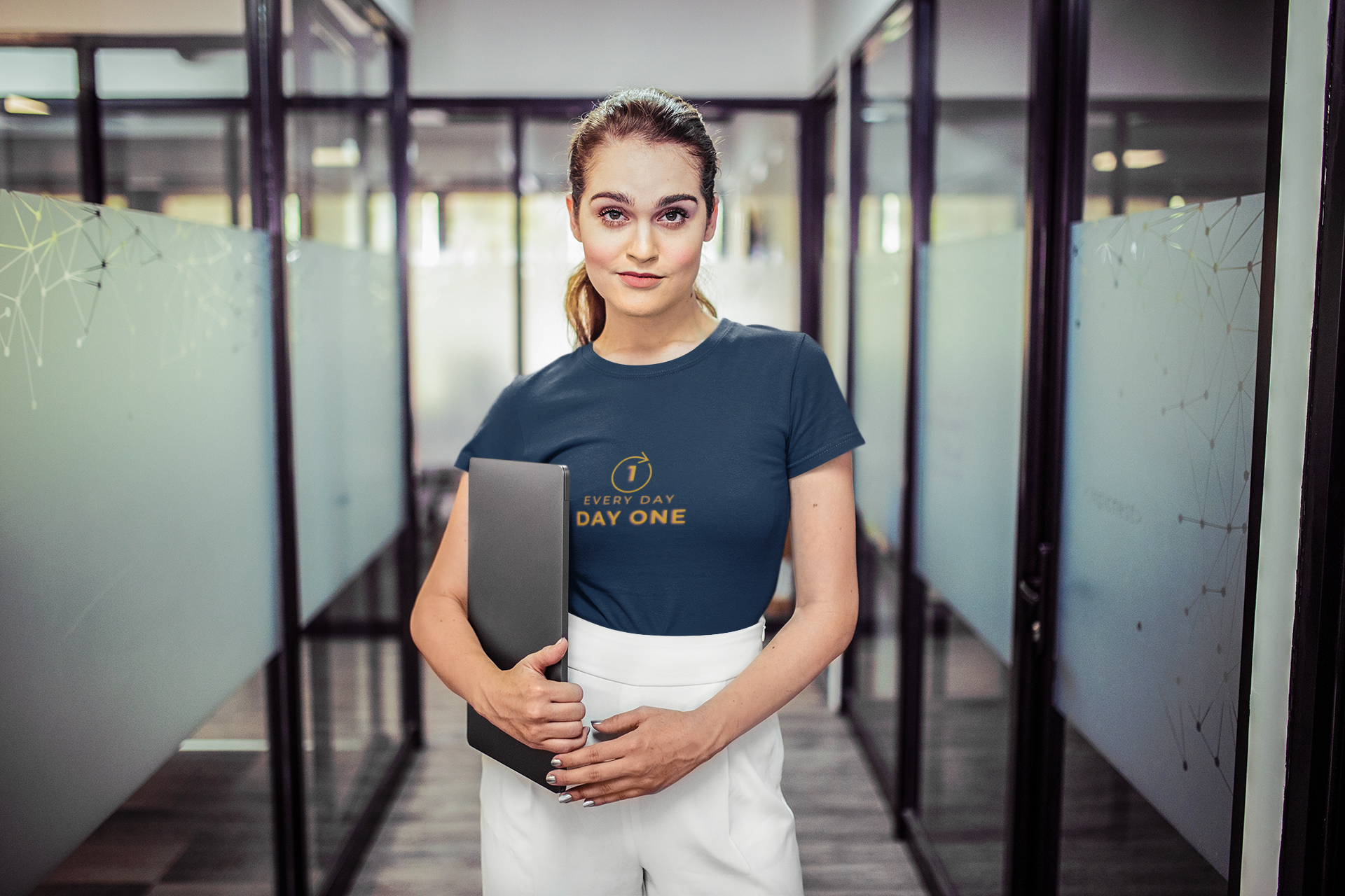 woman-wearing-a-tshirt-mockup-holding-a-laptop-in-a-corridor-at-the-office-a20516_1.png